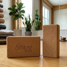 Load image into Gallery viewer, Cork yoga blocks on the floor, two textured rectangular blocks with ombre YOGA logo